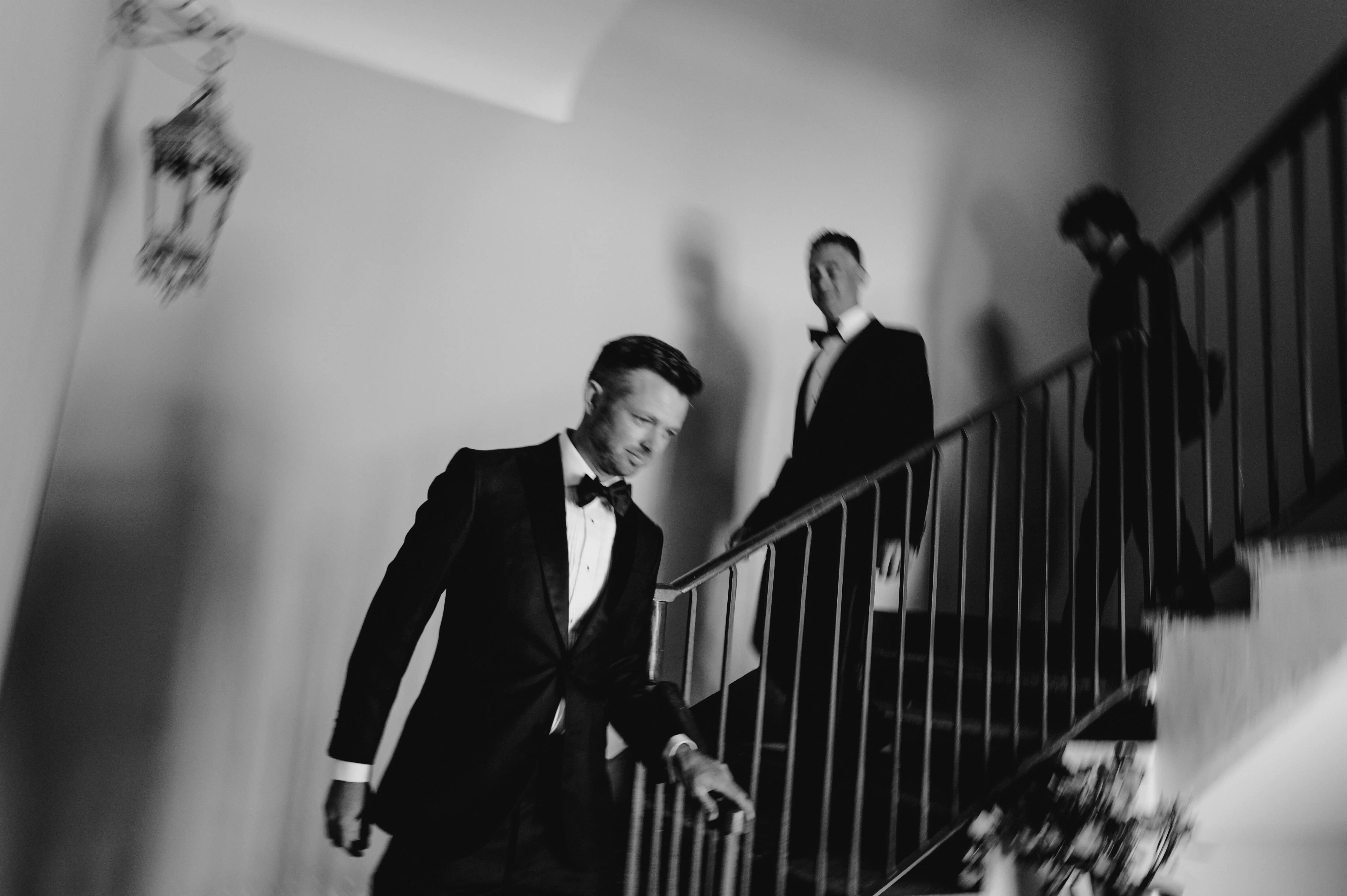 Groom and groomsmen walking downstairs in tuxedos at a luxury Italian wedding venue